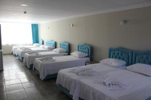 rząd czterech łóżek w pokoju w obiekcie Gorur Suite w Stambule