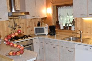 eine Küche mit Herd, Spüle und Mikrowelle in der Unterkunft Ferienhaus-Grünfelder in Lüsen