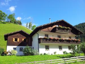 a house with a balcony on a hill at Ferienhaus-Grünfelder in Luson