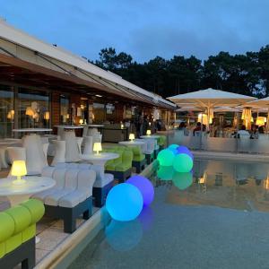 a restaurant with tables and chairs and a pool at Sea Breeze Golf & Beach Villa in Charneca