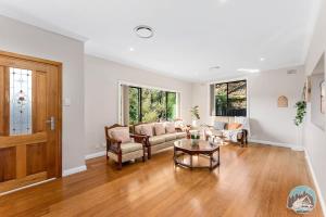 a living room with a couch and a table at Charming 3-Bedroom House in Beacon Hill in Oxford Falls