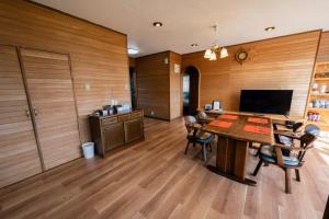 a dining room with a table and chairs and a television at ハレマヤ 一軒家 Haremaya in Ishigaki Island
