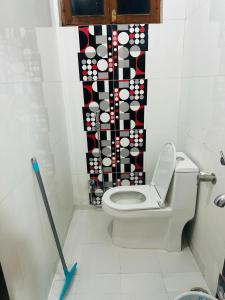 a bathroom with a toilet with a black and white curtain at BuddhaInn-An Enchanted Villa in Varanasi +22 photos