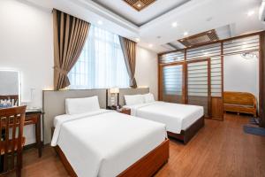 a hotel room with two beds and a desk and a desk at A25 Hotel - 44 Hàng Bún in Hanoi +28 photos
