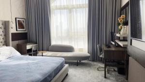 una camera d'albergo con un letto, una scrivania e una finestra di Peace Room opp Ajman City Center 1BHK ad Ajman