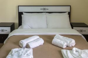 a bed with three folded towels on top of it at Guria Palace in Shekvetili