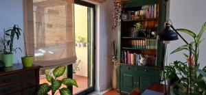 una stanza con una libreria con piante e una finestra di Villa do Lago a Vibeira