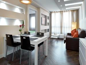 巴塞隆納的住宿－巴塞羅那加烏丁特套房酒店，客厅配有桌子和沙发