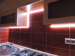 a kitchen with a stove and a tv on the wall at Apartament Violet in Krosno