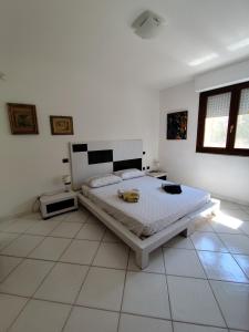 a bedroom with a bed in a white room at Alice e il mare in Alghero