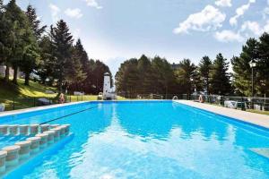 a large swimming pool with blue water at Apart Centro Formigal - WOWRURAL in Formigal