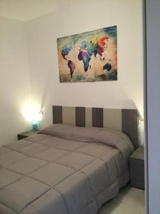a bedroom with a bed with a painting on the wall at A.I.R. Badesi Borgo di Mare in Badesi