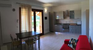 a living room with a table and a kitchen at A.I.R. Badesi Borgo di Mare in Badesi