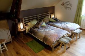 a bedroom with two beds and two chairs at Maison d hôtes "Aux Légendes d Ardenne" in Carlsbourg