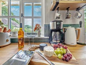 - un comptoir de cuisine avec une cafetière et quelques plats dans l'établissement Willow Tit Cottage, à Capel-Cynon