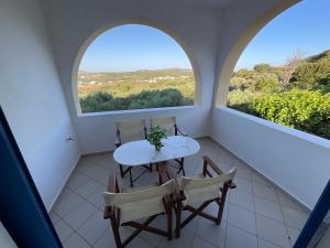 a table and chairs in a room with two windows at Petros Studios Kythera in Kythira