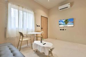 a living room with a couch and a table at De Helga Apartment Chaloklum in Ko Phangan
