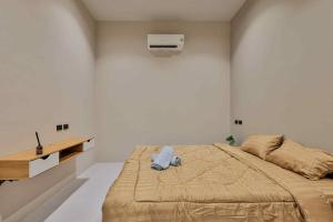 a bedroom with a bed with a blue towel on it at De Helga Apartment Chaloklum in Ko Phangan