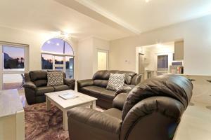 a living room with two couches and a table at Camps Bay Beach Apartment in Cape Town