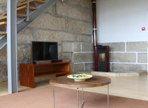 sala de estar con mesa y TV en Alojamento Rural de Covelas, en Covelas