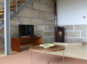 a living room with a table and a tv at Alojamento Rural de Covelas in Covelas