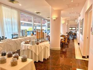 a restaurant with tables with white table cloth at Greif Hotel Maria Theresia in Trieste