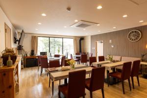 a dining room with tables and chairs and aktop at 軽井沢フォーシーズホテル in Karuizawa