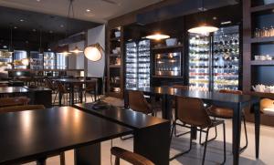 a restaurant with tables and chairs and wine bottles at Octant Ponta Delgada in Ponta Delgada