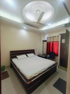 a bedroom with a large bed with a ceiling at Saluja Palace in Rāe Bareli