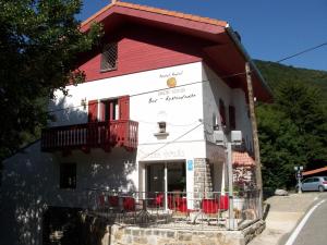 un petit bâtiment blanc avec un toit rouge dans l'établissement Hostal Rural Arrobi Borda, à Eugi