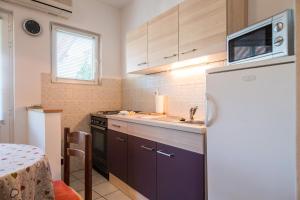 a kitchen with a refrigerator and a sink at Garden Apartments in Komiža +26 photos