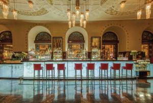 a bar in a building with red stools at Grand Hotel Europe, A Belmond Hotel, St Petersburg in Saint Petersburg