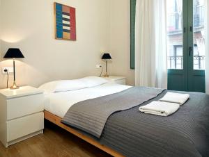une chambre avec un lit avec deux serviettes dessus dans l'établissement Barcelona Mercaders Apartments, à Barcelone