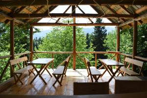 a wooden porch with tables and chairs on it at Kirari Mount Camp in Zemo-Margi