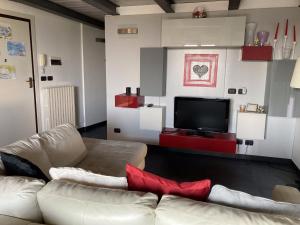 a living room with a white couch and a tv at Happy House Montemarciano in Montemarciano