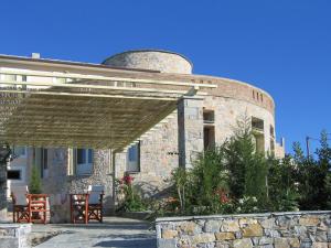 a stone house with a round building with a roof at Villa Rotunda in Alonissos Old Town in Alonnisos