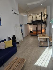 Una sala de estar con un sofá azul y una mesa. en Vintage duplex with jacuzzi, en Málaga