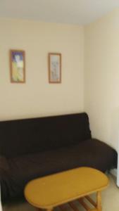 a living room with a black couch and a wooden table at Hostal las Parcelas in Conil de la Frontera