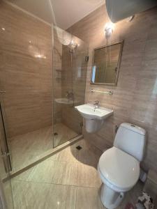 a bathroom with a toilet and a sink and a shower at Dawn Park Deluxe in Sunny Beach