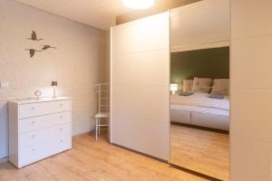 Un dormitorio con una cama y un espejo grande. en Lütt Heidjer Hus, en Buchholz in der Nordheide