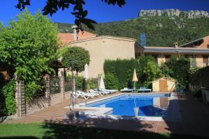 a house with a swimming pool with a mountain in the background at Cabañas los Pinos Arroyo Frio in Arroyo Frio