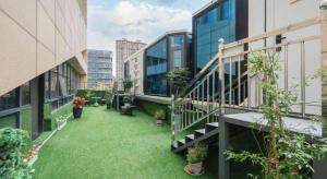 a balcony with green grass and plants on a building at Lavande Hotels Xuzhou Yunlong Wanda Medical University in Xuzhou