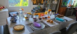 a table with food and drinks on it in a kitchen at TiNat chambre avec grand jardin, parking gratuit in Douarnenez
