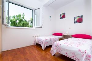 a bedroom with two beds and a window at Vila Dunja in Makarska +22 photos