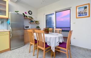 a kitchen with a table with chairs and a refrigerator at Vila Dunja in Makarska