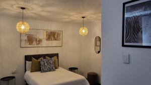 a bedroom with two lights and a bed in it at Villa Tlhago Lodge in Ga-Mothapo