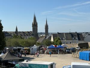 a market in a city with a clock tower at Maison de ville avec jardin clos 4 Pers in Saint-Pol-de-Léon