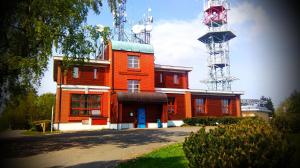 塞米利Riegrova Chata Kozákov的一座橙色的建筑,上面有一座塔