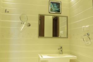 a white bathroom with a sink and a mirror at شقق الكادي السكنية للشقق المخدومة in Najran +17 photos
