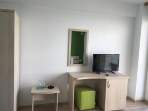 a room with a desk with a television and a mirror at Pensiunea Andra in Costinesti